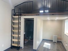 an empty room with stairs leading up to the second floor and a window on the far wall