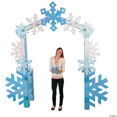 a woman standing in front of an archway made out of snowflakes