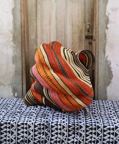 an orange hat sitting on top of a blue and white table cloth next to a wooden door