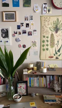 a desk with a laptop and some pictures on the wall