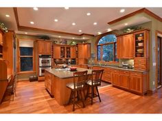 a large kitchen with wooden cabinets and an island