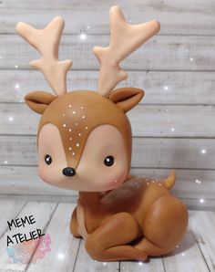 a small deer figurine sitting on top of a wooden floor next to a wall