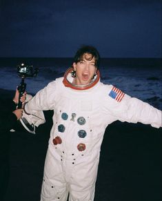 a man in an astronaut suit on the beach