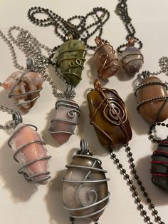 These impressive hand wrapped pendant necklaces are sure to delight with their unique shapes & color combinations. Aside from #2 & #10, the pendants are agates. They can easily be taken off the chain they come with and put on your favorite necklace chain. They will undoubtedly add a new dimension to any outfit. I collected the rocks walking the shores of Lake Superior and then tumbled and polished them before hand wrapping them in wire. River Rock Jewelry, Multicolor Wire Wrapped Crystal Necklace As Gift, Multicolor Wire Wrapped Necklace For Gift, Artisan Hand Wrapped Pendant Crystal Necklaces, Multicolor Wire Wrapped Pendant Necklace, Agate Pendant Necklace With Raw Stone, Artisan Hand Wrapped Pendant Crystal Necklace, Wire Wrapped Amulet Pendant Crystal Necklace, Wire Wrapped Amulet Crystal Pendant Necklace