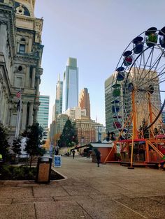 an amusement park with ferris wheel and buildings in the background