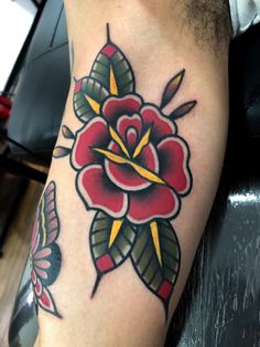 a close up of a person's leg with a rose tattoo design on it