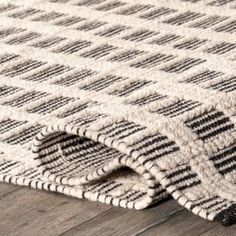 a close up view of a rug on the floor with wood floors in the background