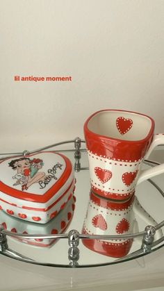 two heart shaped mugs on a glass shelf