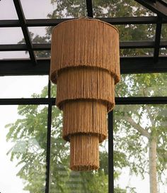 a large bamboo light hanging from the ceiling in a room with glass walls and windows