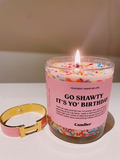 a candle that is sitting on a table next to a bracelet with the words go shawty it's yo'yo'birthday