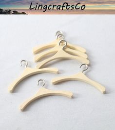 four wooden hangers with hooks on them in front of a beach and sky background