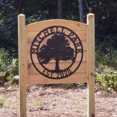 a wooden sign sitting in the middle of a forest