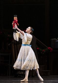 a woman in a white dress holding a red object