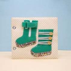 a pair of green boots sitting on top of a card