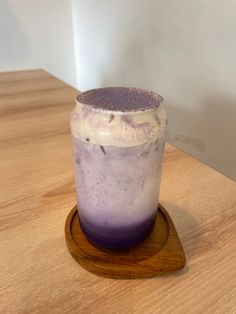 a purple drink sitting on top of a wooden table