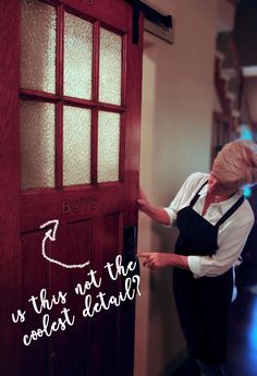 a woman standing in front of a red door