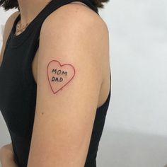 a woman with a tattoo on her arm that says mom dad and a red heart