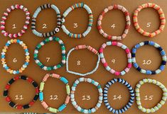 a table topped with lots of colorful bracelets on top of a wooden table covered in numbers