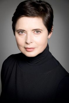 a woman with short hair wearing a black turtle neck shirt and looking at the camera