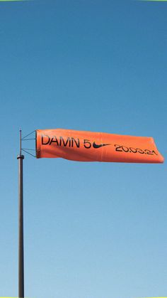 an orange banner is hanging from a pole