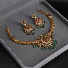 a gold necklace and earring set in a box