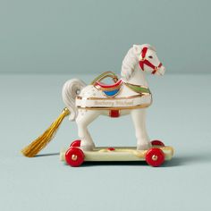 a white toy horse with red wheels and a gold mane on it's back