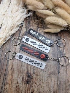 three metal key chains with the words harry potter on them sitting on a wooden surface