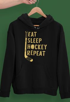 a black hoodie with the words eat sleep hockey repeat on it hanging from a hanger