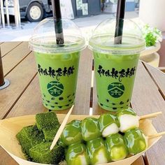 two cups of green tea with chopsticks and broccoli on a table