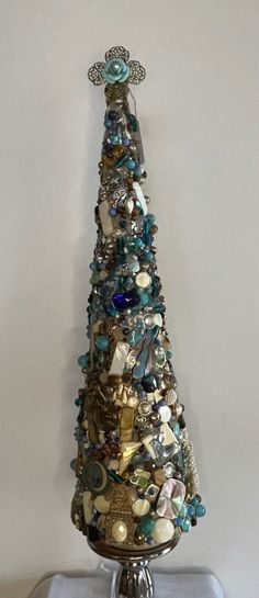 a christmas tree made out of shells and other items on top of a metal stand