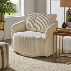 a living room scene with focus on the couch and chair in the foreground, along with potted plants