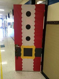 a door decorated to look like santa clause is on the floor in an empty hallway