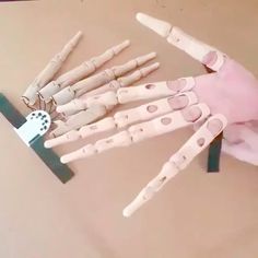 a hand made out of white plastic with holes in the middle and several other parts attached to it