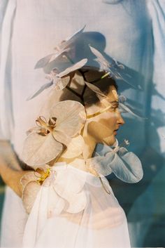 a woman with flowers on her head in front of a white background and the image is blurry