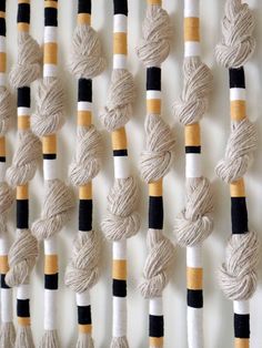 several skeins of yarn are hanging on a wall with black and white stripes