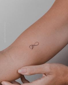 a woman's arm with a small tattoo on the left side of her arm