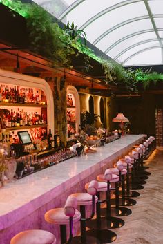 the bar is lined with pink stools