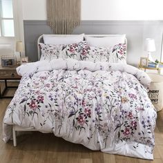 the comforter is made with white and purple flowers