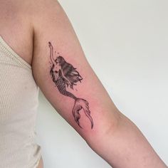 a woman's arm with a fish tattoo on it