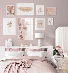 a bedroom with pink walls and pictures on the wall above the bed in front of it