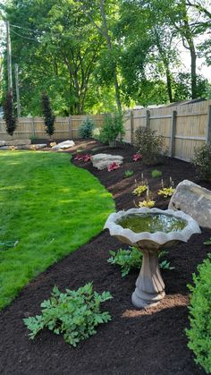 a bird bath sitting in the middle of a garden