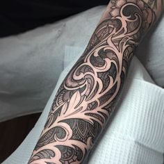 a man's arm with an intricate tattoo design on the forearm and hand area