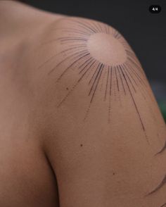 the back of a man's shoulder with lines drawn on it and sunburst