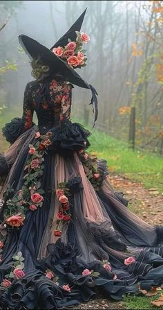 a woman in a black dress with flowers on it and a large hat over her head