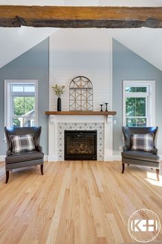 a living room with two chairs and a fireplace in the middle of it's walls