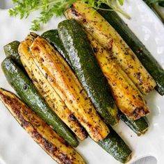 grilled zucchini on a white plate with parsley