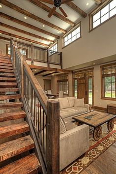 a living room filled with furniture and wooden stairs