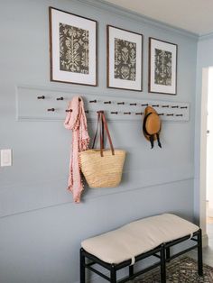 there is a bench and two pictures on the wall in this entryway with a coat rack