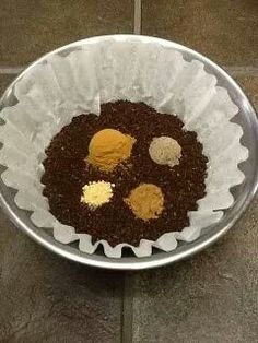 a metal bowl filled with food on top of a tiled floor