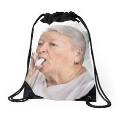 an old woman with white hair is holding something in her mouth while wearing a black drawsack bag